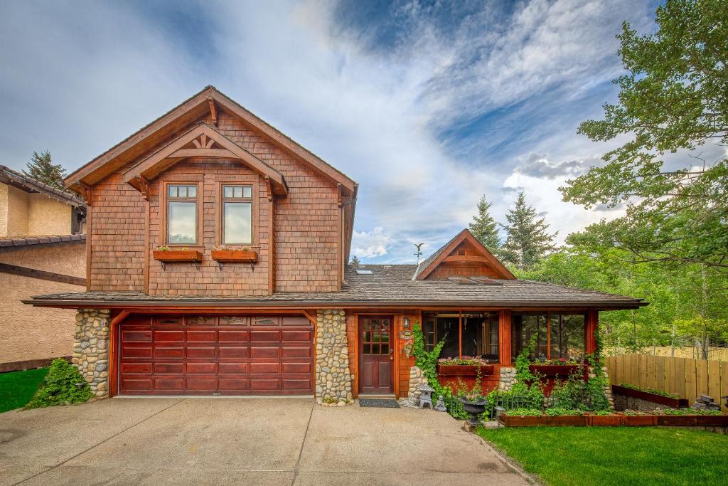 a brown brick house with a garage at B&B on Mountain Lane - Private Suite & Hot Tub in Banff