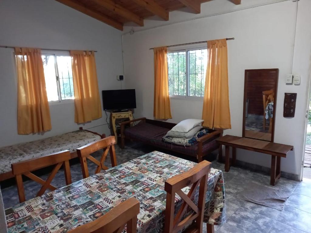 uma sala de estar com duas camas e uma televisão em Cabaña Serrana em Santa Rosa de Calamuchita