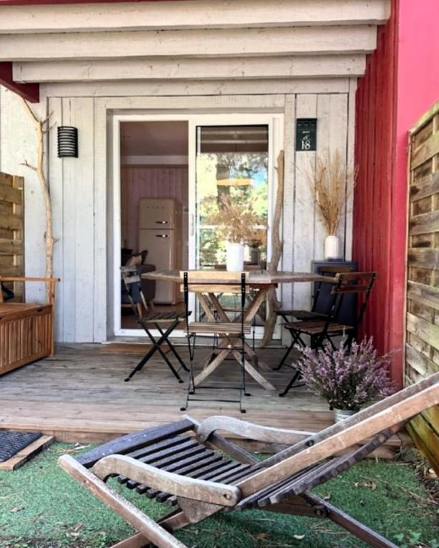 une terrasse en bois avec une table et des chaises dessus dans l'établissement Beautiful 3 rooms with terrace near the ocean, à Moliets-et-Maa