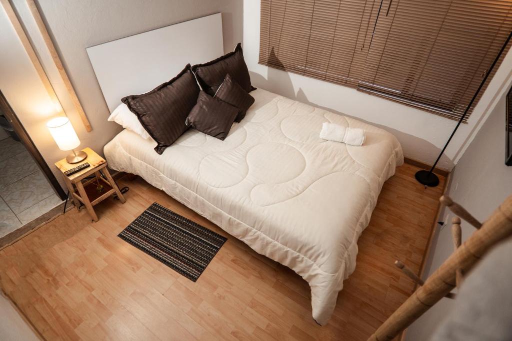 eine Aussicht auf ein Bett in einem kleinen Zimmer in der Unterkunft Hotel Primitivo Usaquén in Bogotá