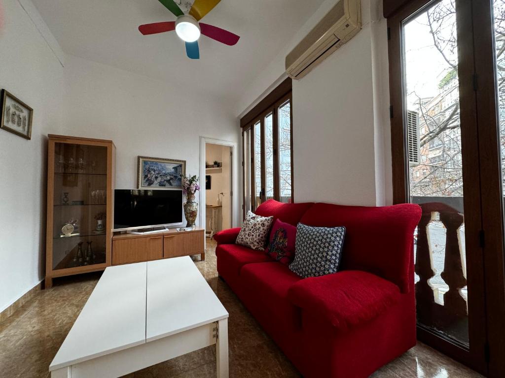 a living room with a red couch and a tv at Ruzzafa Codrut in Valencia