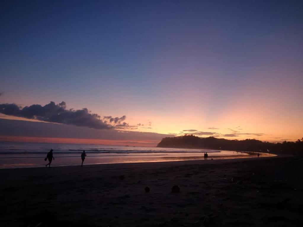 a group of people walking on the beach at sunset at Cat’onas apatment in Nicoya