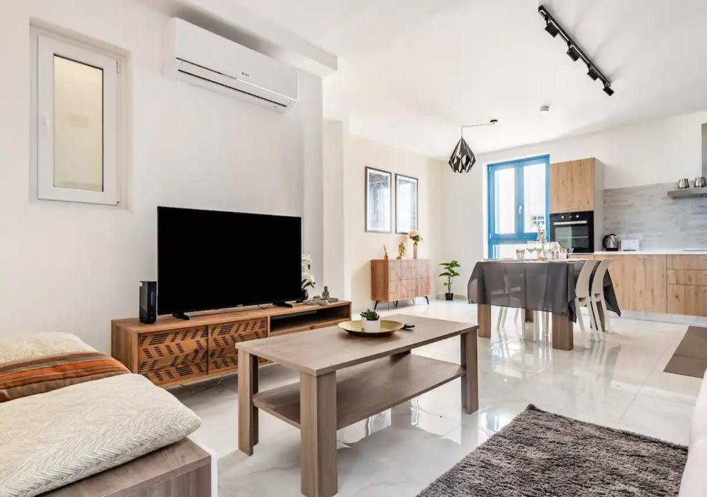 a living room with a flat screen tv and a table at Sea View Luxury Apartment Brand New in Valletta in Valletta