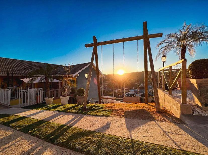 a wooden cross in a yard with a swing at Pousada Geada de Campos in Campos do Jordão