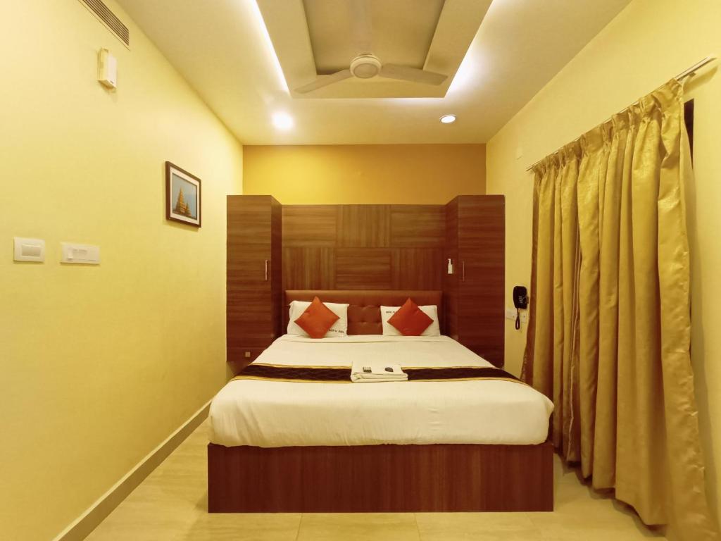 a bedroom with a large bed with a wooden headboard at MRV Inn Triplicane in Chennai