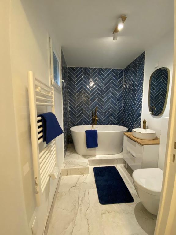 bagno con vasca, lavandino e servizi igienici di Les belles nuits d'honfleur a Équemauville