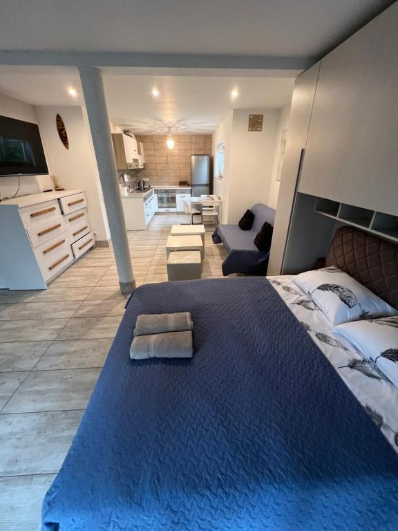 a bedroom with a large blue bed and a kitchen at HELLO House in Alytus