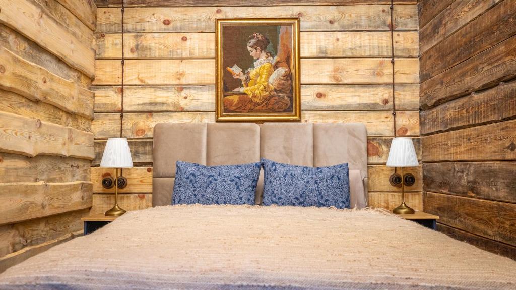 a bedroom with a bed with a painting on the wall at Chalet Mountain Deer in Kolašin