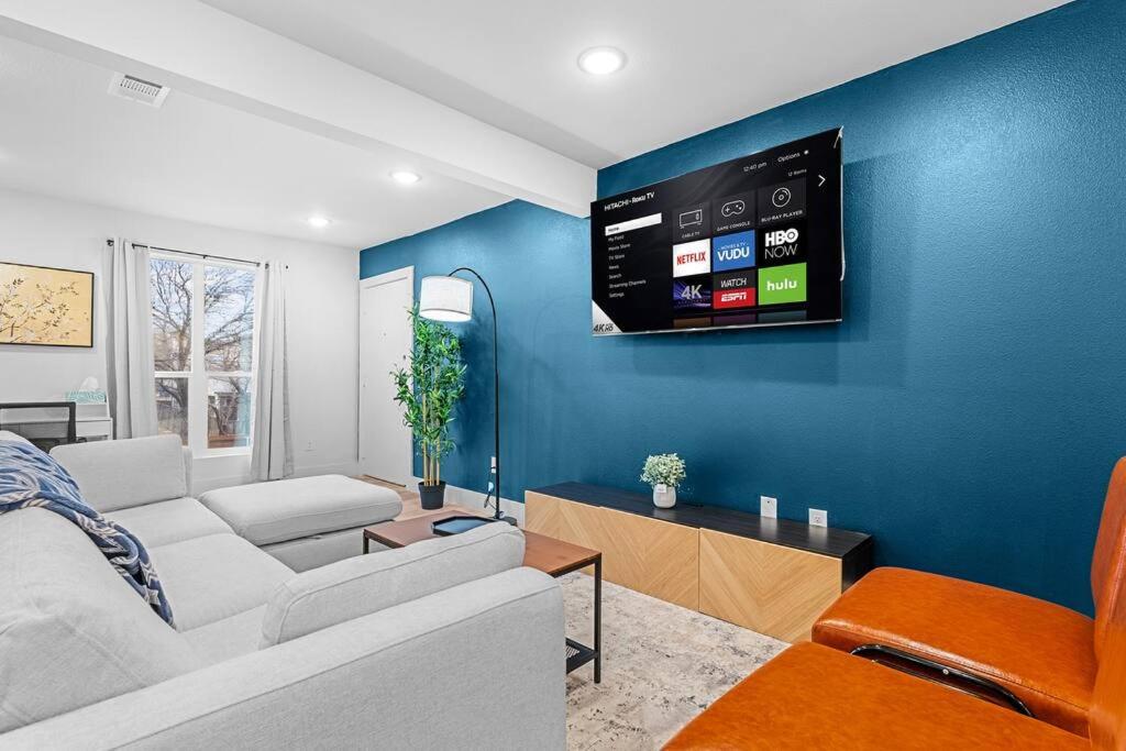 un salon avec un canapé et une télévision sur un mur bleu dans l'établissement Stylish 2 bed 1 Mile to downtown Free parking, à Dallas