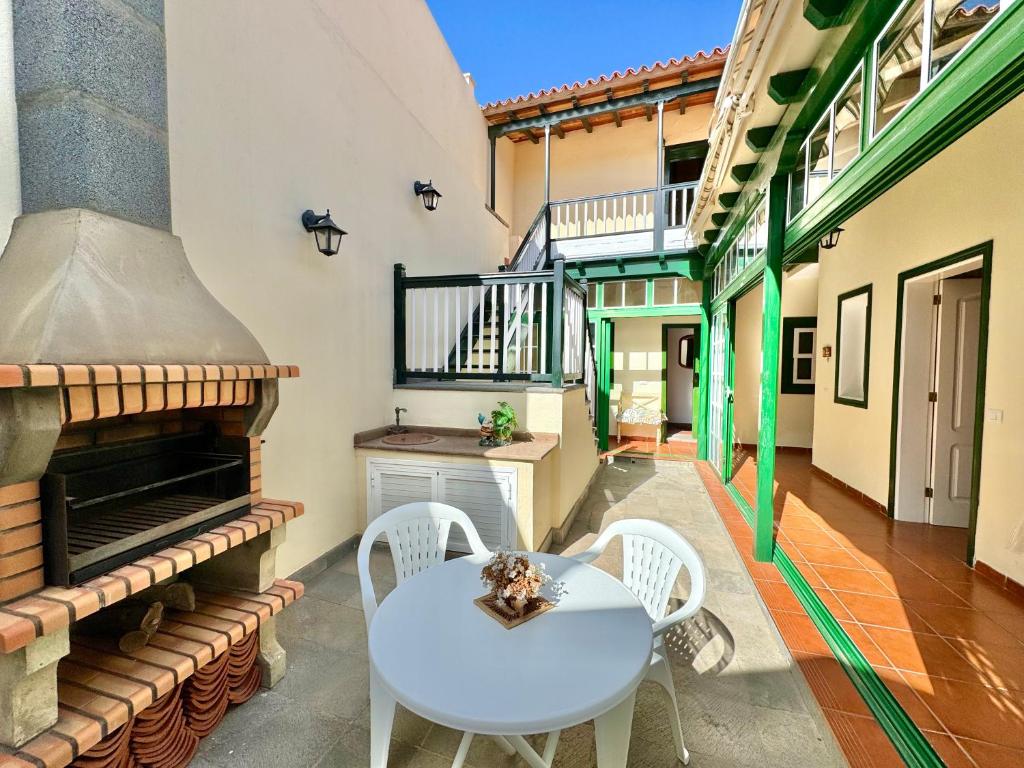 a patio with a table and chairs and a stove at Guanche 'Casa rural canaria' in San Miguel de Abona