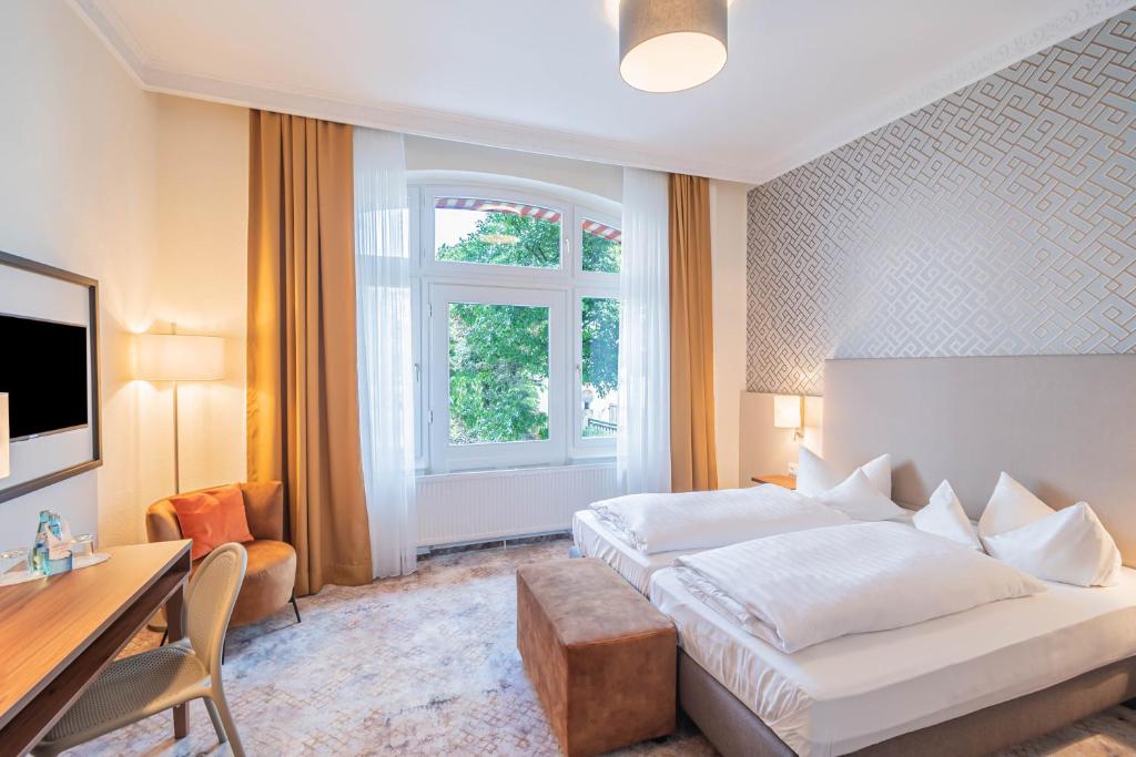 a hotel room with a bed and a desk at Hotel Villa am Kurpark in Bad Homburg vor der Höhe