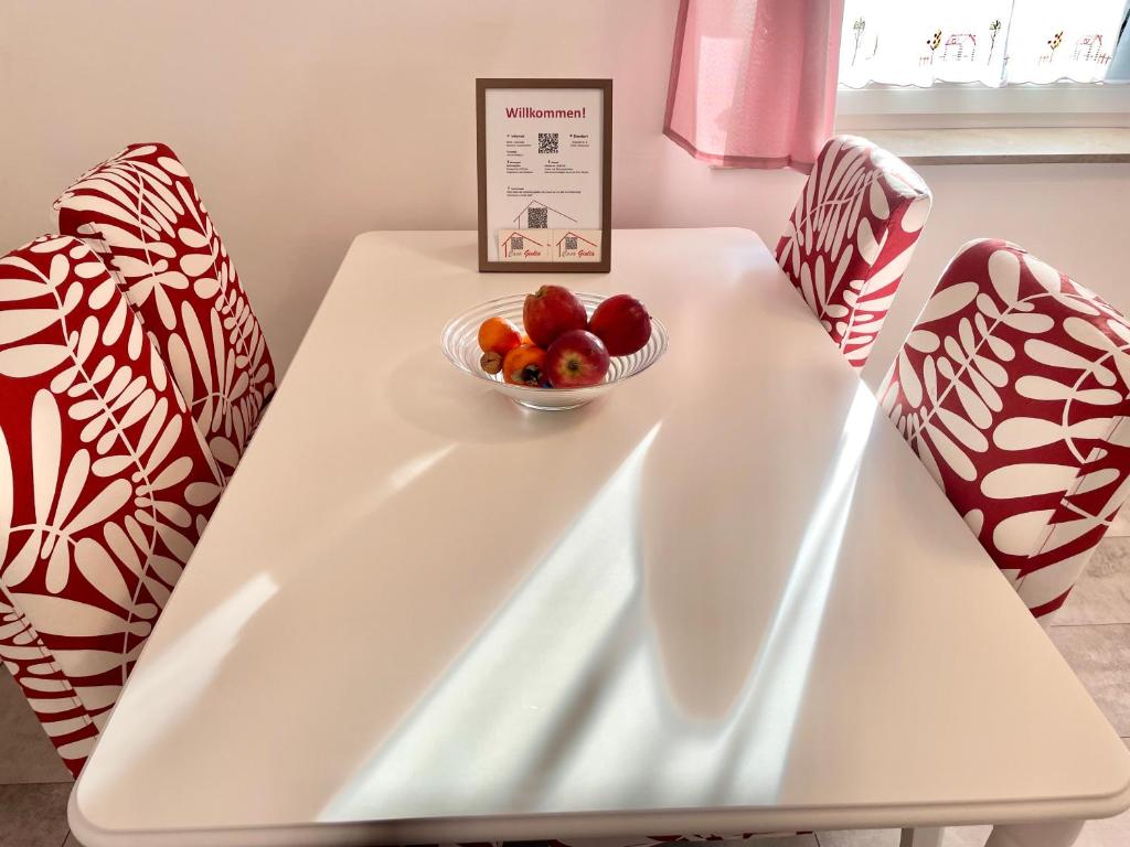 - une table blanche avec un bol de fruits dans l'établissement Casa Giulia 2 Zimmer, Küche, Bad, WLAN, Parkplatz, à Gleiberg