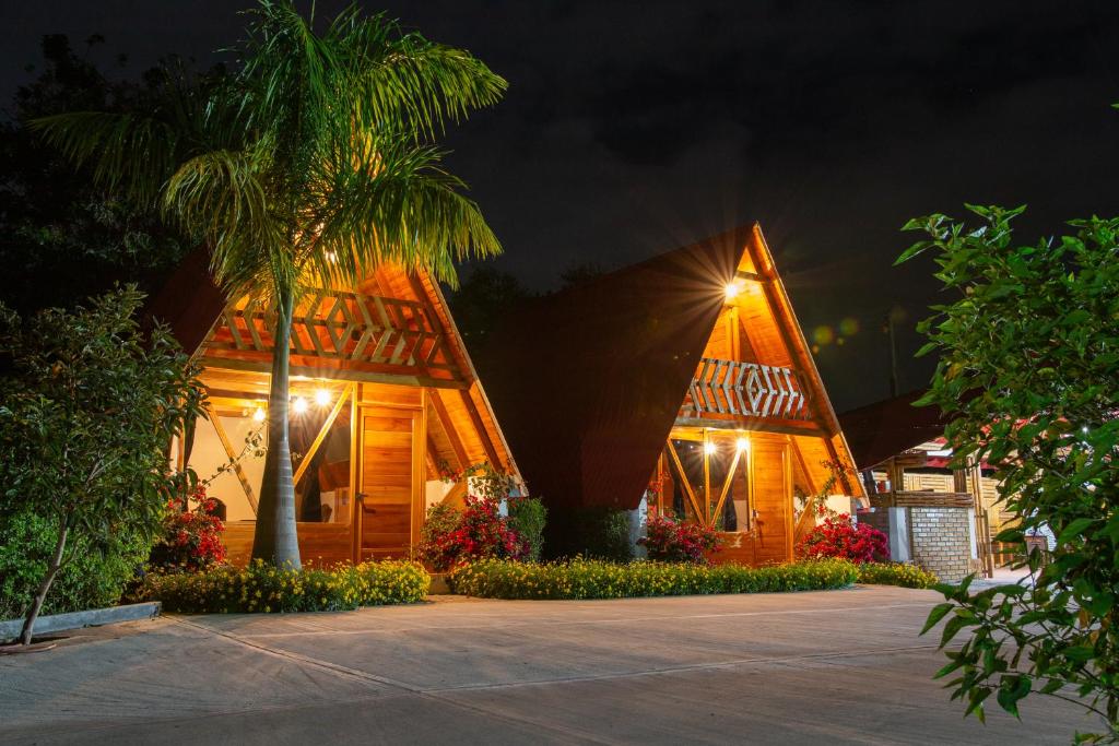 a resort with a palm tree and a building at Cabañas Amalú in San Agustín