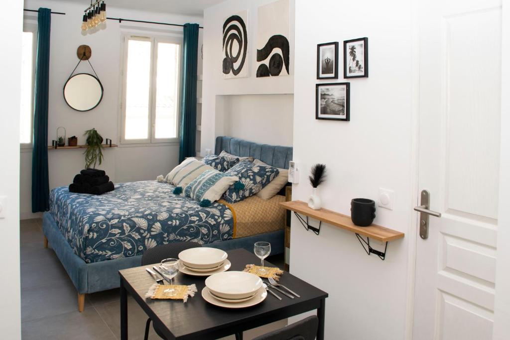 ein Schlafzimmer mit einem Bett und einem Tisch mit Tellern darauf in der Unterkunft Au Pied du Vieux-Port Wifi Netflix in Marseille