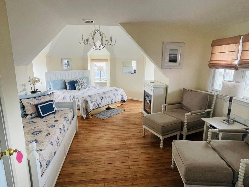een slaapkamer met een bed, een bank en een stoel bij The Grenville Hotel and Restaurant in Bay Head