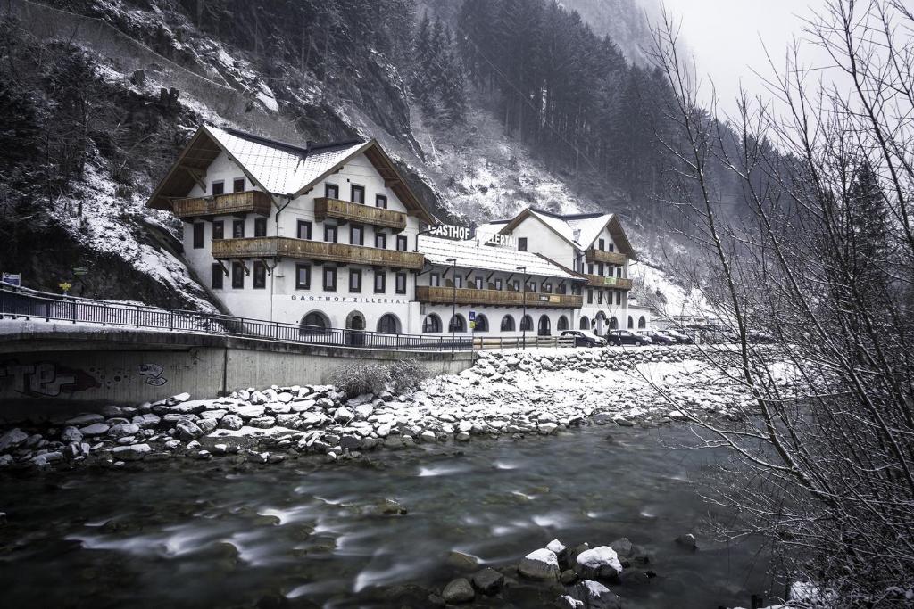 a large building on a bridge over a river at Hostel Chillertal in Mayrhofen