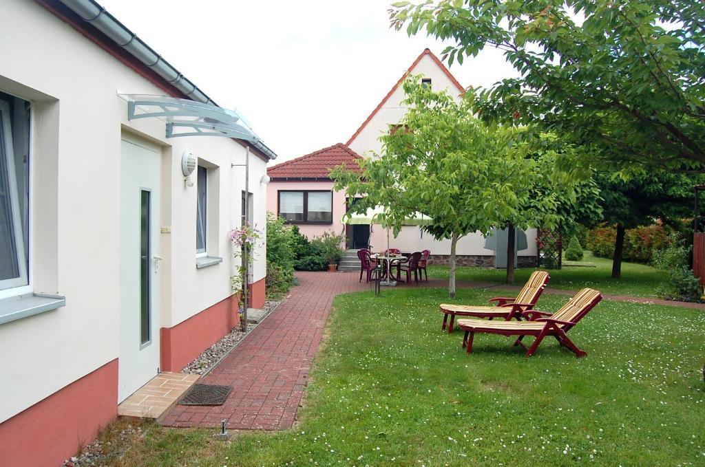 einen Hof mit Bänken und Tischen und ein Haus in der Unterkunft Ferienwohnung Peise in Flecken Zechlin