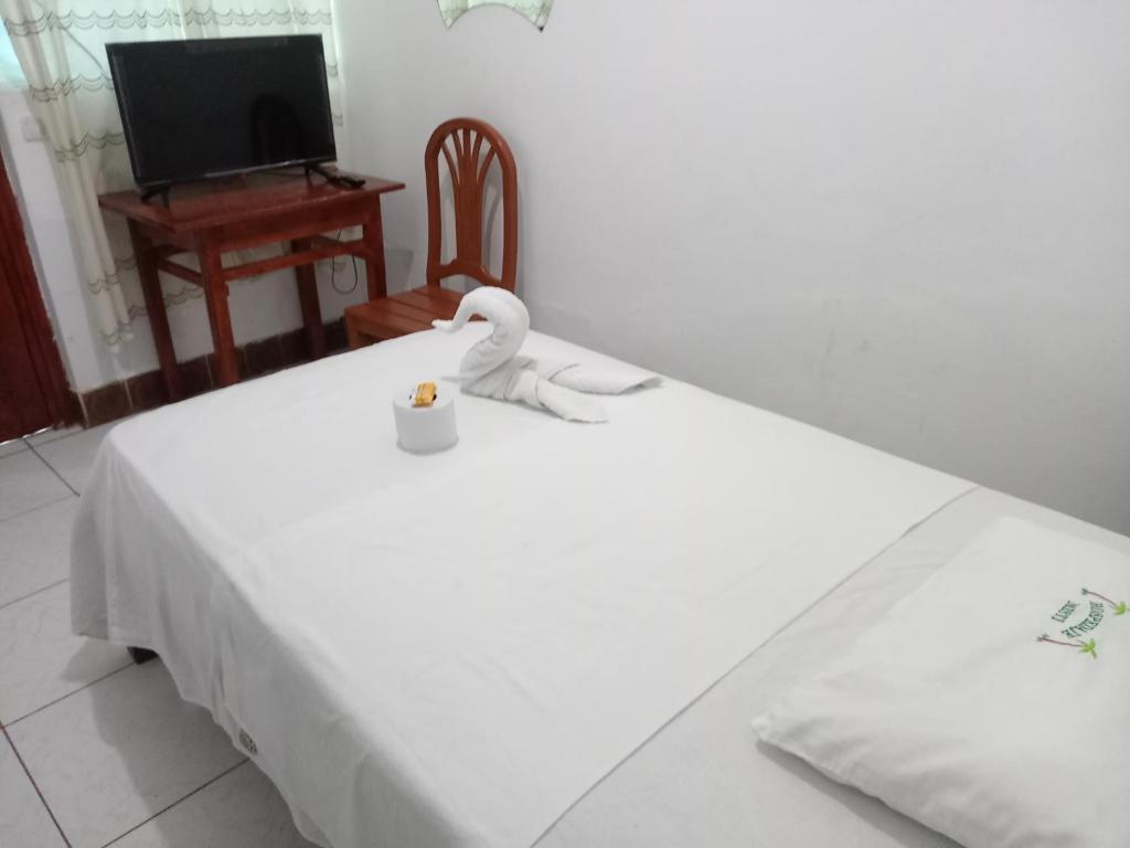 uma cama branca com um cisne em cima em Misti em Tarapoto
