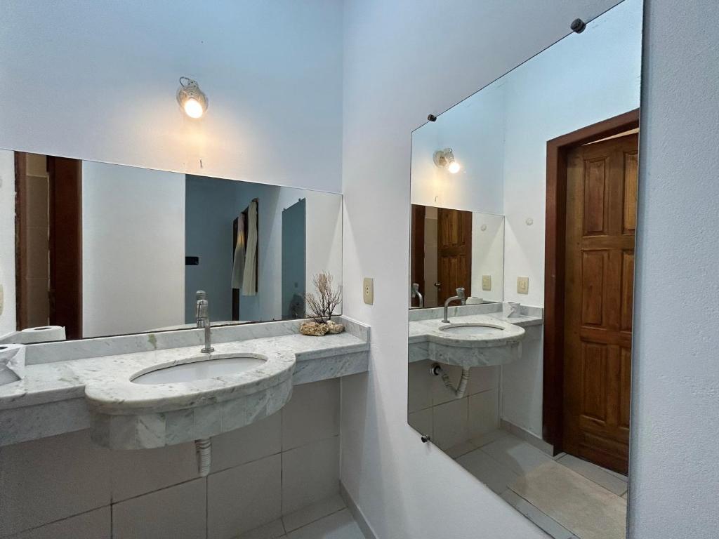 a bathroom with two sinks and a large mirror at Morada Pedra da Lua in Porto Seguro