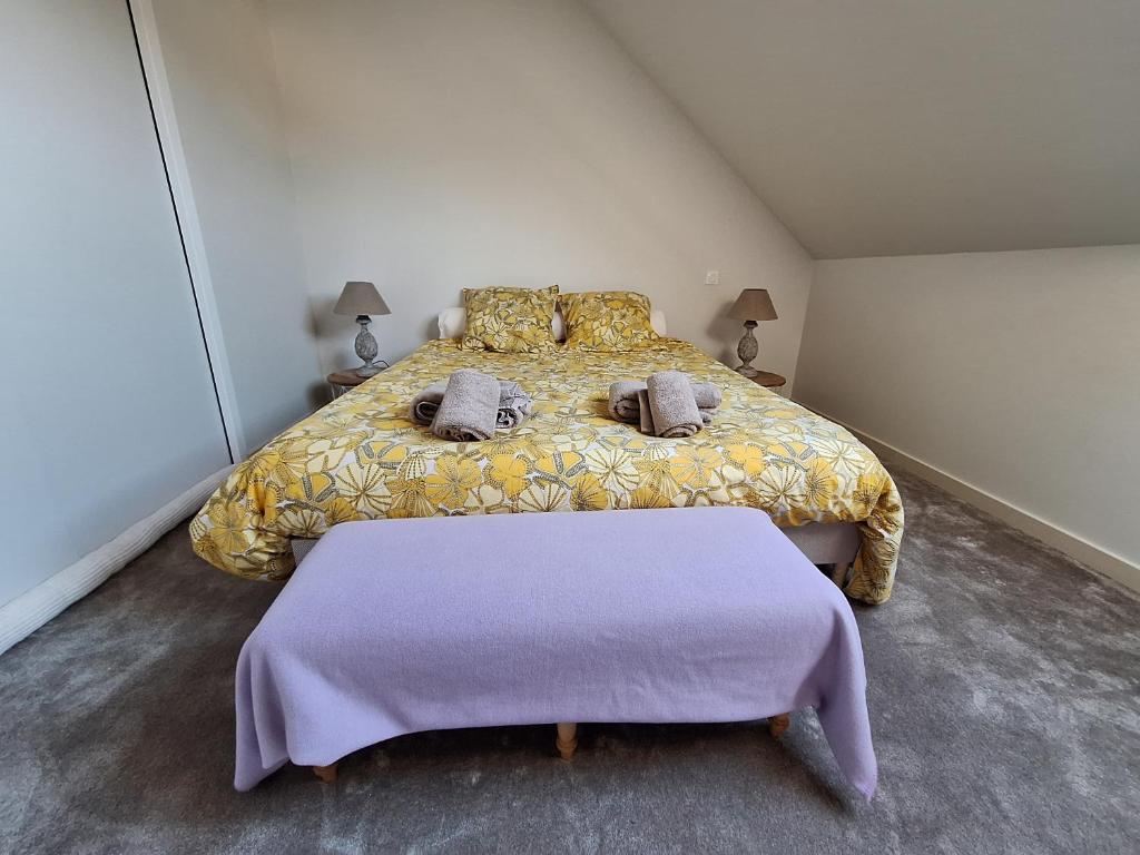 a bedroom with a bed with two pillows at La chambre Mademoiselle Causeuse in Malville