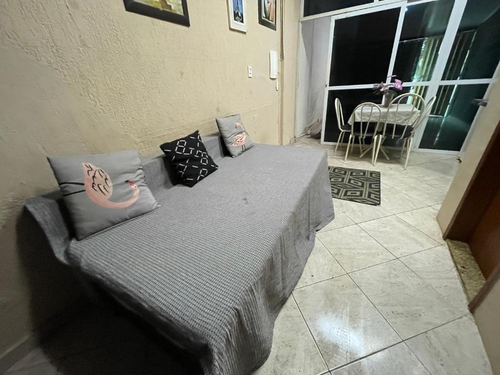 a bed with pillows on it in a room at Kit Centro Extra in Campos dos Goytacazes