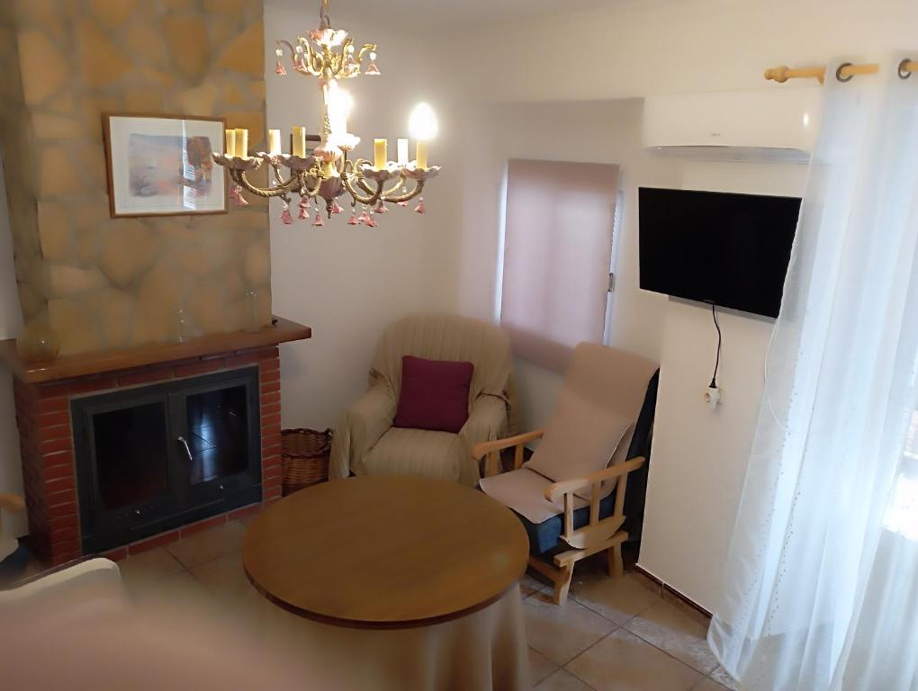 a living room with a chair and a table and a tv at Alojamiento Rural Villa Baja - Castril in Castril