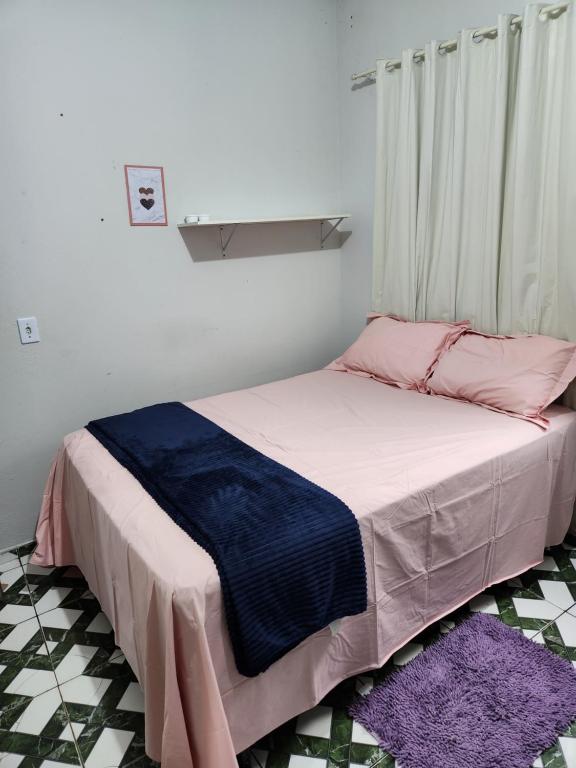 a bedroom with a bed with pink and blue sheets at Casa favorita in São Raimundo Nonato