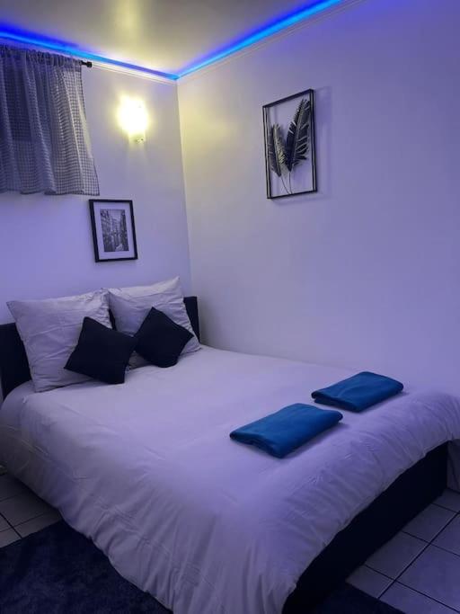 une chambre avec un grand lit blanc avec des oreillers bleus dans l'établissement Charmant studio Paris 17ème, à Paris