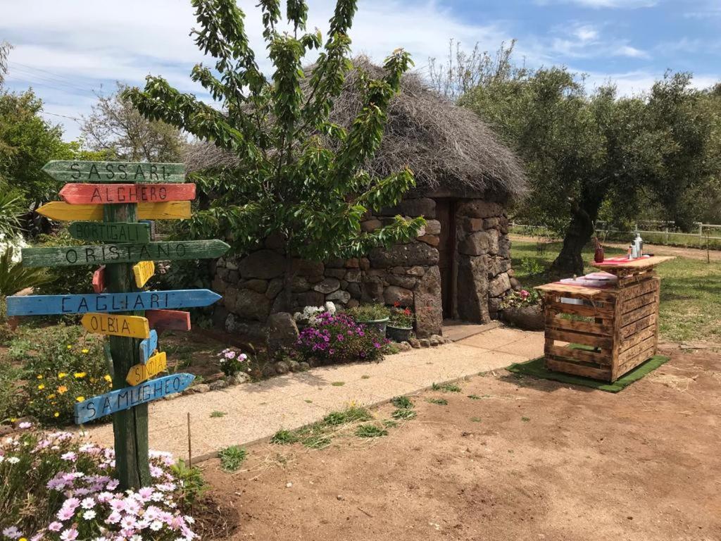 una señal direccional frente de un edificio de piedra en Azienda agricola Affittacamere S'Ispinalba di Laura Pitzolu, en Borore