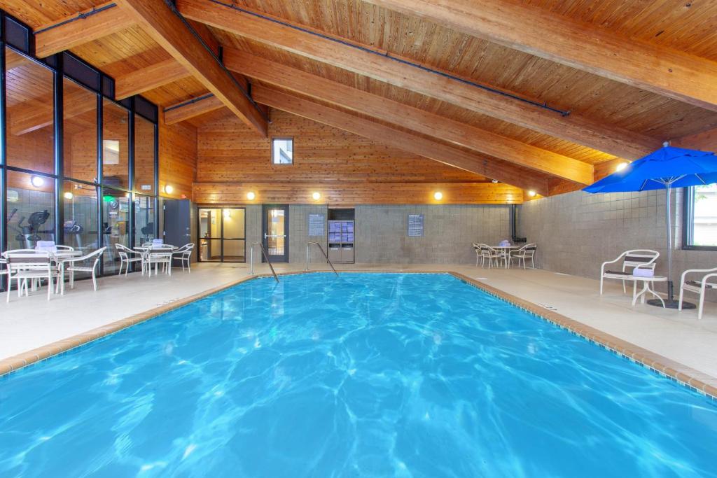 a large pool in a building with tables and chairs at AmericInn by Wyndham Mankato Event Center near MSU in Mankato