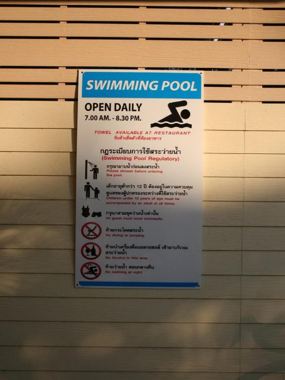 A posted sign lists the pool’s daily hours and usage rules.