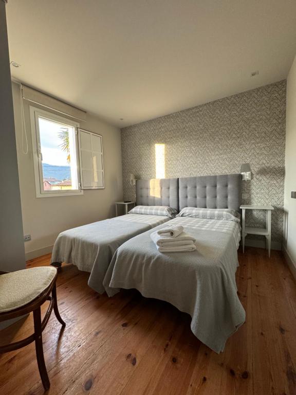 - une chambre avec un lit doté de draps blancs et une fenêtre dans l'établissement Villa Rosa bella, à Poo de Llanes