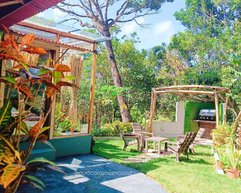 un patio trasero con sillas y pérgola de madera en Cabaña de Montaña Puro Corazón en Los Altos de Cerro Azul