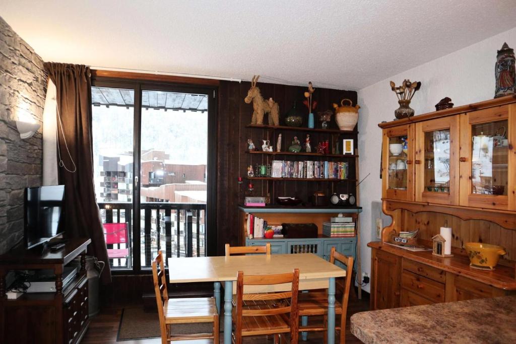 a dining room with a table and chairs and a window at Résidence Les Carlines - 2 Pièces pour 6 Personnes 011 in Les Orres