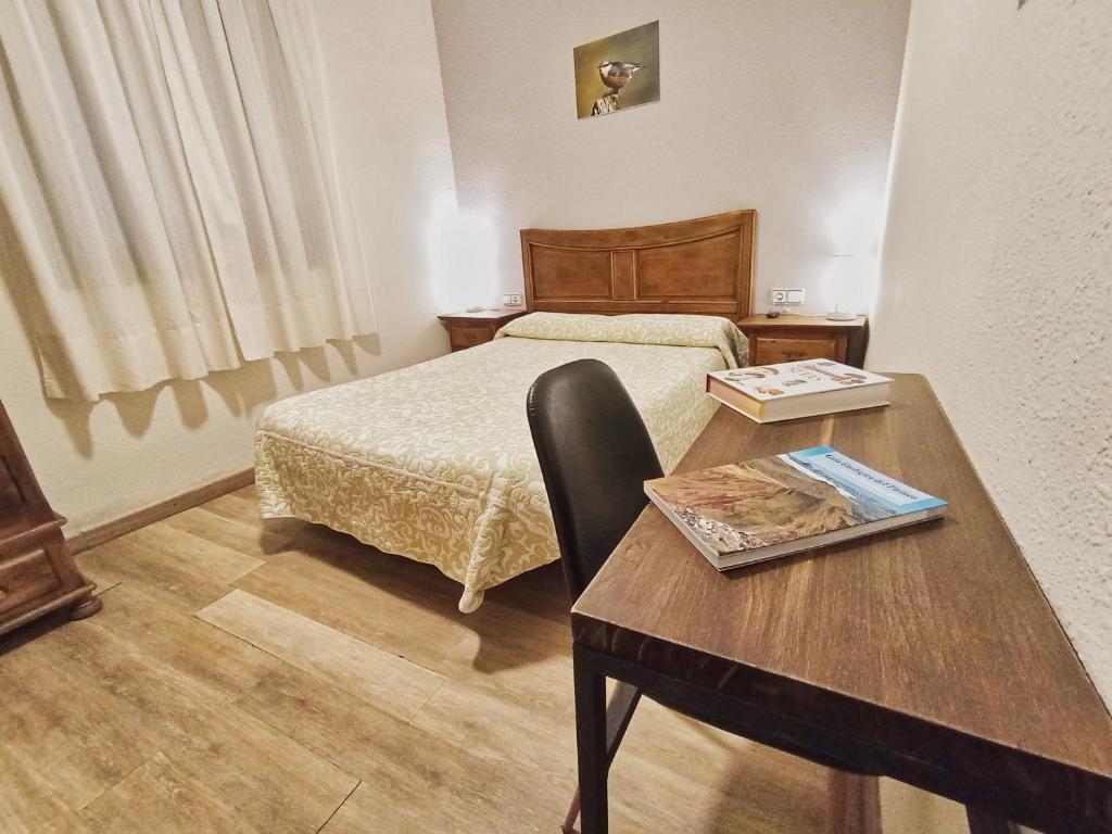 Zimmer mit einem Bett, einem Tisch, einem Bett und einem Schreibtisch in der Unterkunft Casa Gerbe in Gerbe