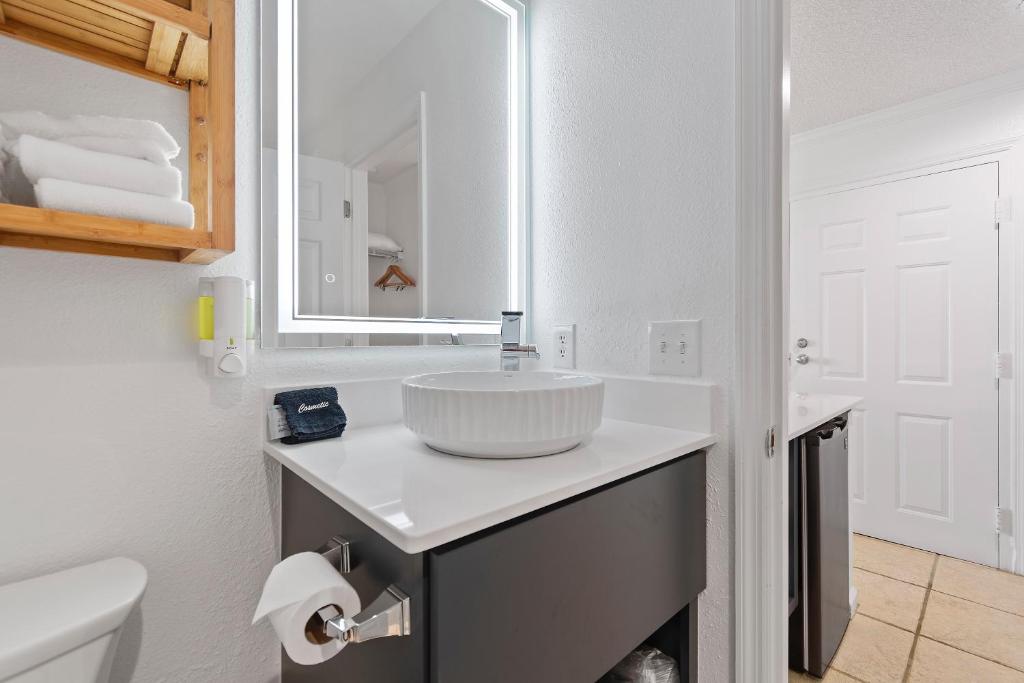 a white bathroom with a sink and a mirror at Ocean Isle Inn in Ocean Isle Beach