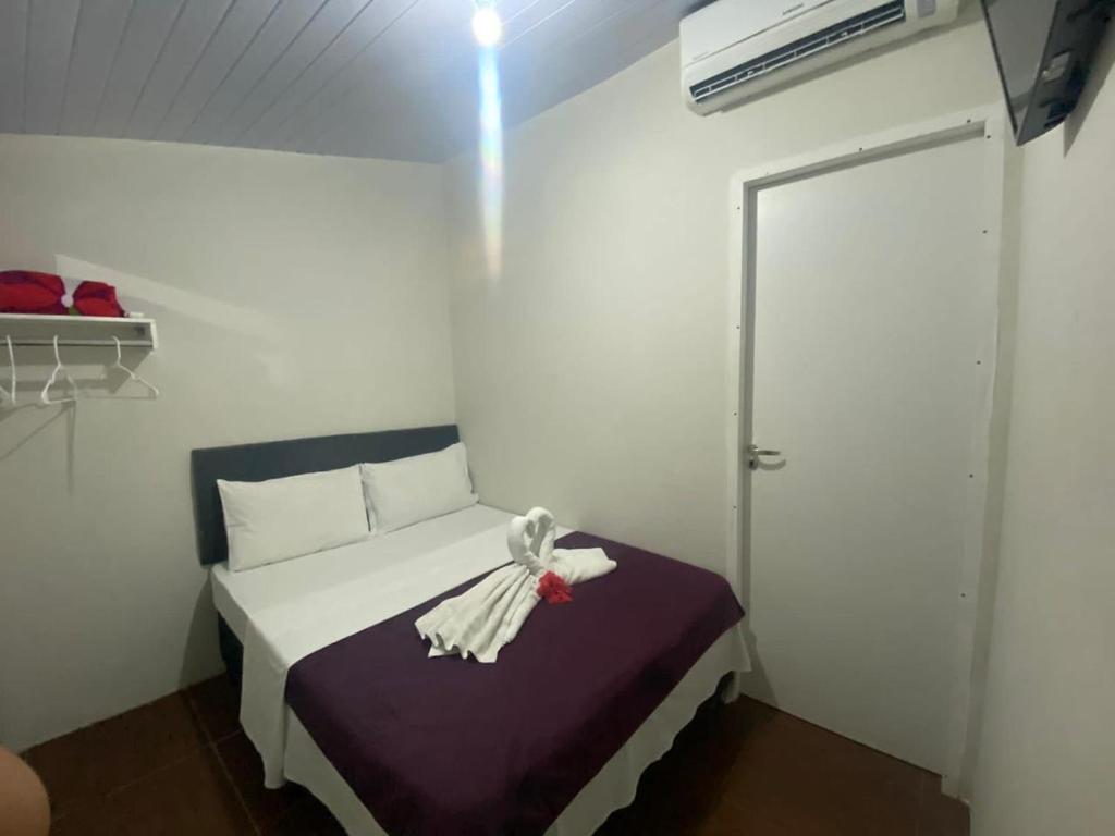 um pequeno quarto com uma cama com um vestido em Boldro Surf House em Fernando de Noronha