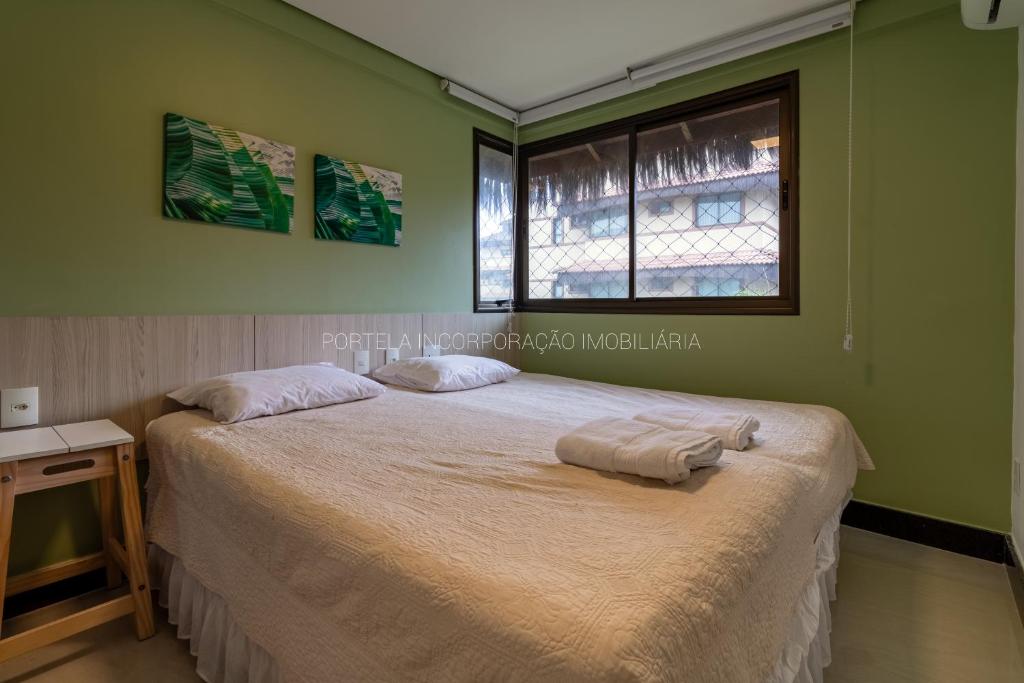 una camera da letto con un letto con due cuscini sopra di Manhattan Beach Riviera ad Aquiraz