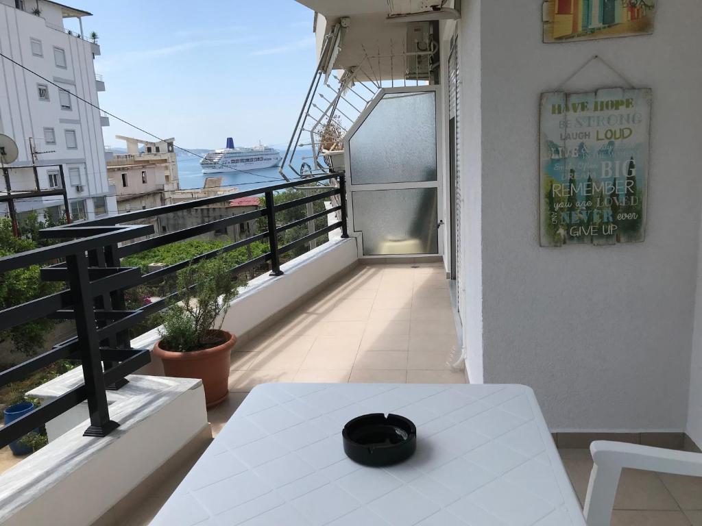 einen Balkon mit einem Tisch und Meerblick in der Unterkunft Kosta's Apartment in Sarandë