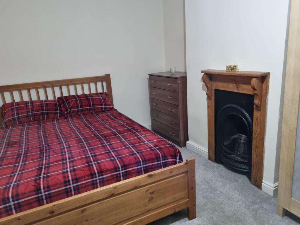 um quarto com uma cama, uma lareira e uma cómoda em Excellent stay em Leicester