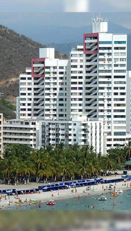 a group of people on a beach in front of buildings at Condominio Santa Maria del Mar torre B apto 704 in Santa Marta