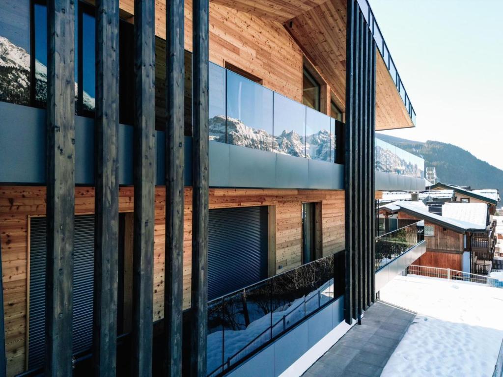 Chalet Larix Andalo Deluxe Apartments في أندالو: اطلالة خارجية على مبنى فيه جبال في الخلفية