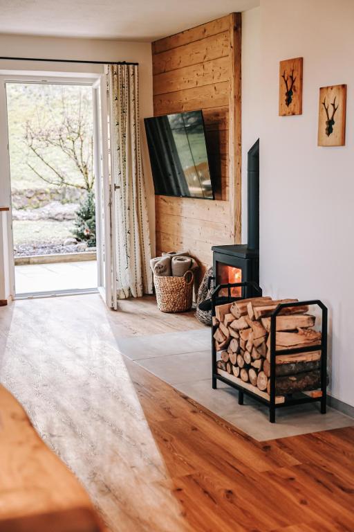 a living room with a fireplace and a television at Ferienwohnung Söldenköpfl-Blick in Schönau am Königssee