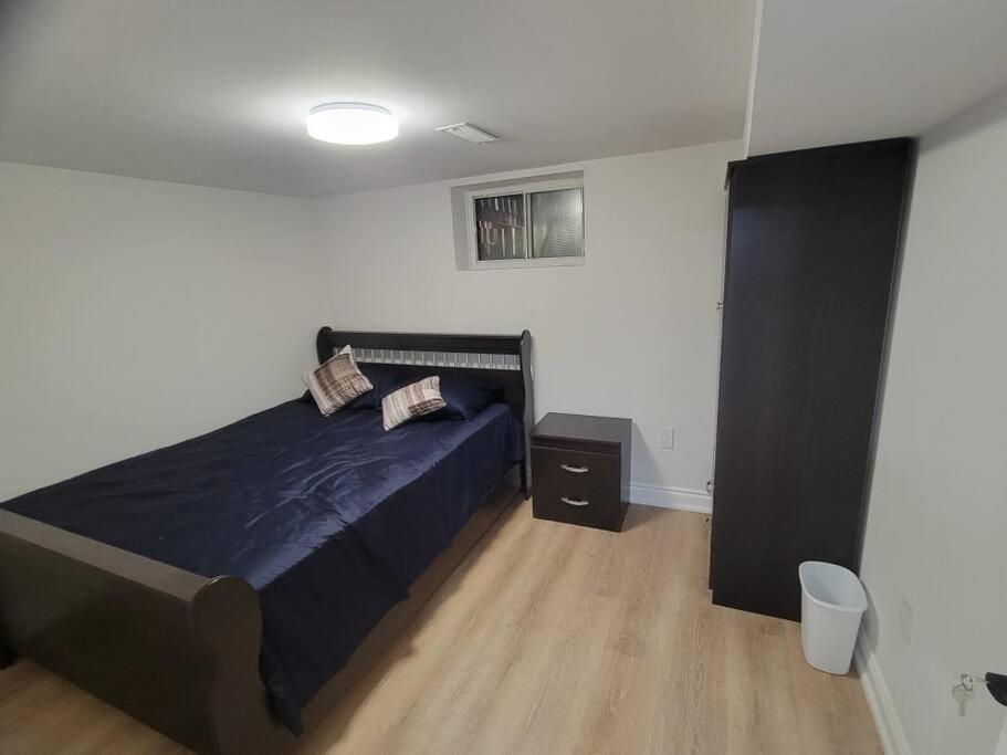 um quarto com uma cama com um edredão azul em Basement apartment, 25 Minutes to Downtown em Toronto