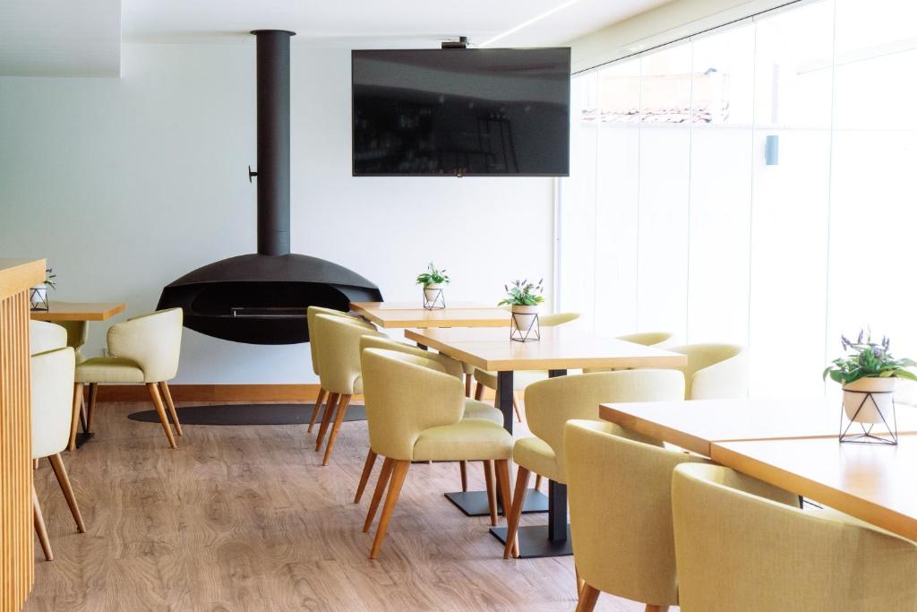 uma sala de jantar com mesas e cadeiras e uma lareira em Douro Castelo Signature Hotel & Spa em Lamego
