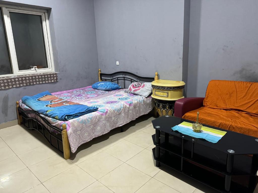 a room with two beds and a couch and a table at Faris Guest House in Sharjah
