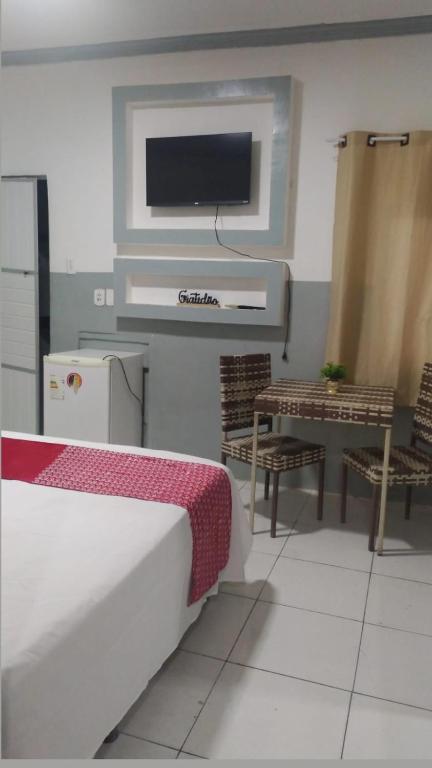 1 dormitorio con TV, mesa y cama en HOTEL CYSNE, en Sobral