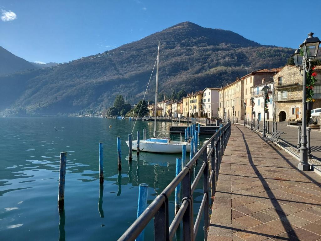 un barco está atracado en un muelle junto al agua en Miralago Casa Vacanze, en Riva di Solto