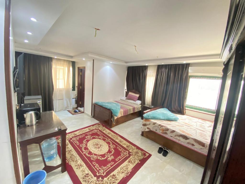 1 dormitorio con 2 camas, mesa y ventana en شقق فندقيه بمدينه المنصوره en Ṭalkha