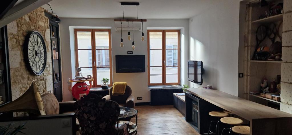 a living room with a clock on the wall at CAPUCINE in Bourges